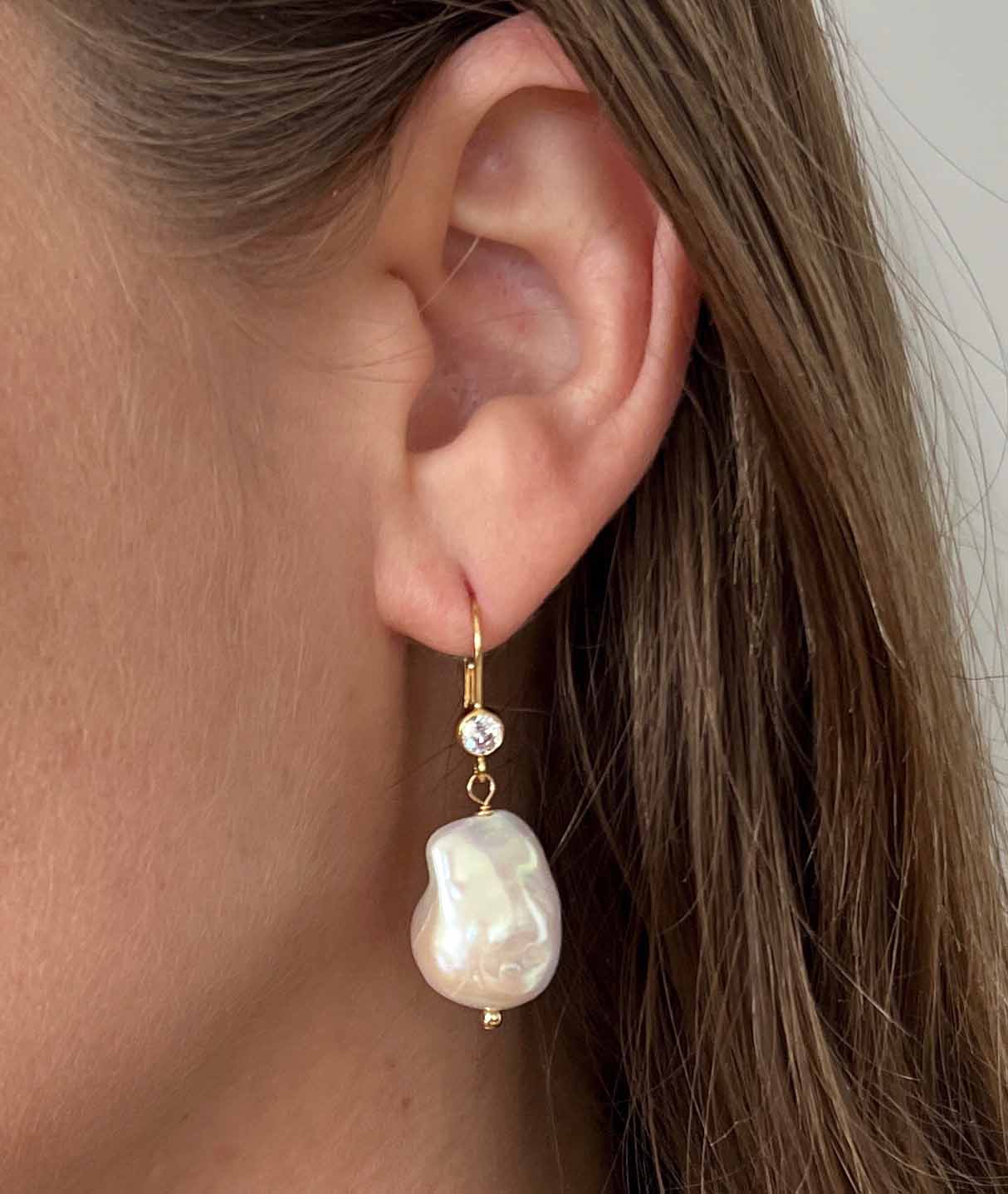 close up of baroque pearl earrings on leverback ear wires