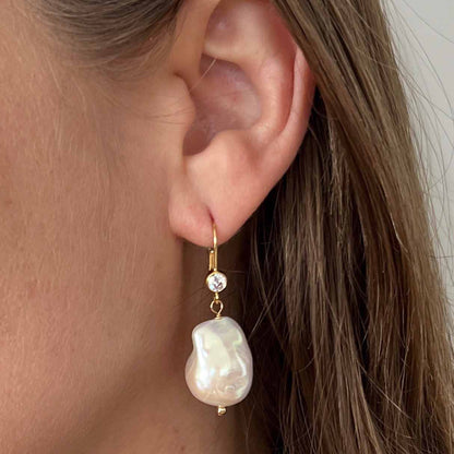 close up of baroque pearl earrings on leverback ear wires