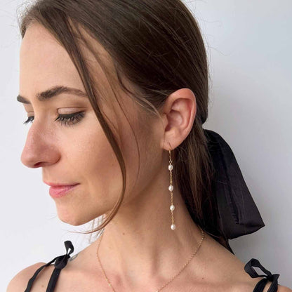 model wearing long pearl earrings with leverback ear wire