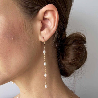close up of model with lever back long pearl earrings in 14k gold fill
