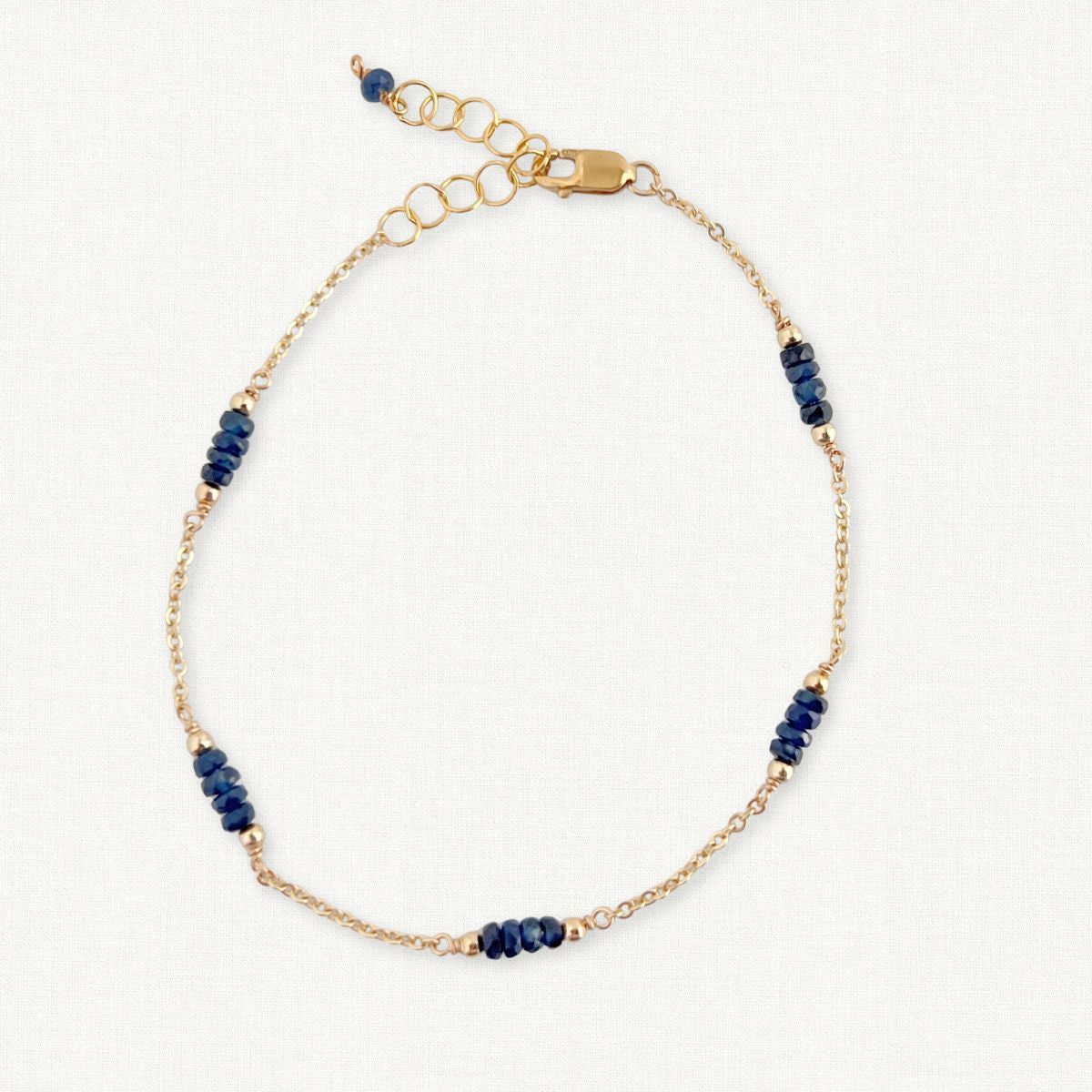 Gold Chain and Sapphire Bracelet on White Background