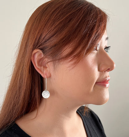 model wearing sterling silver hammered disc dangle earrings