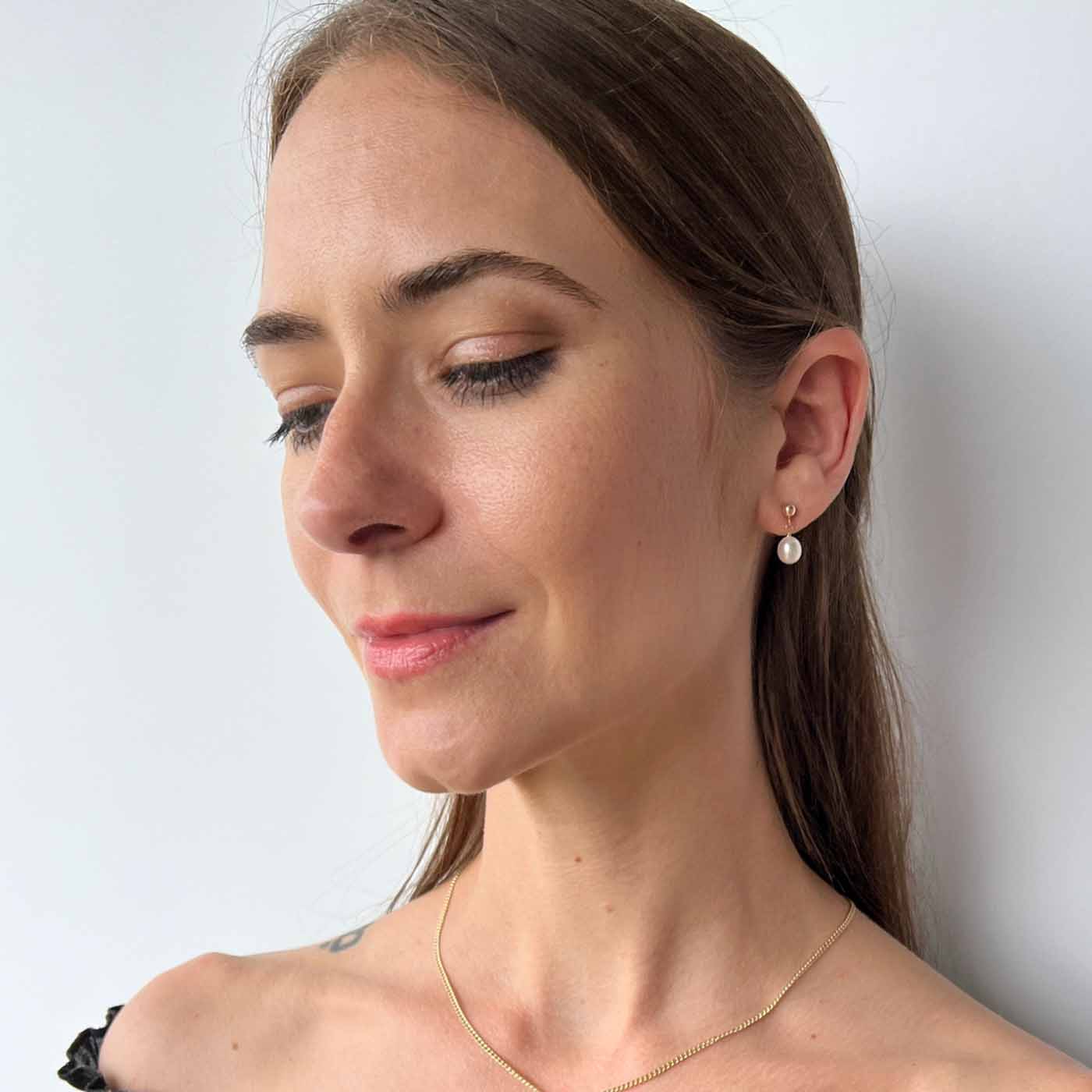 model wearing Nicola pearl drop earrings in 14k gold fill
