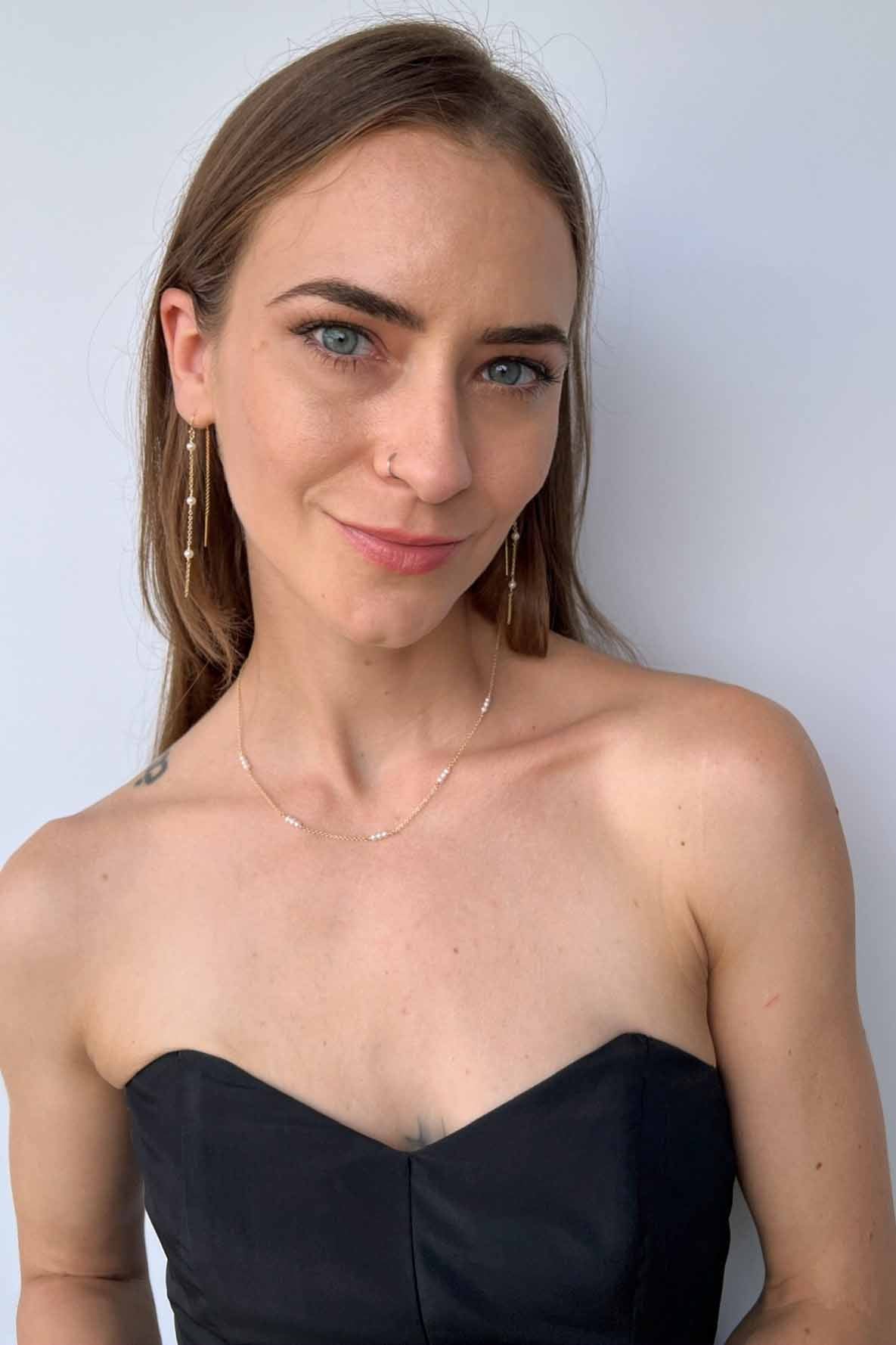 model wearing set of pearl chain earrings and dainty pearl necklace