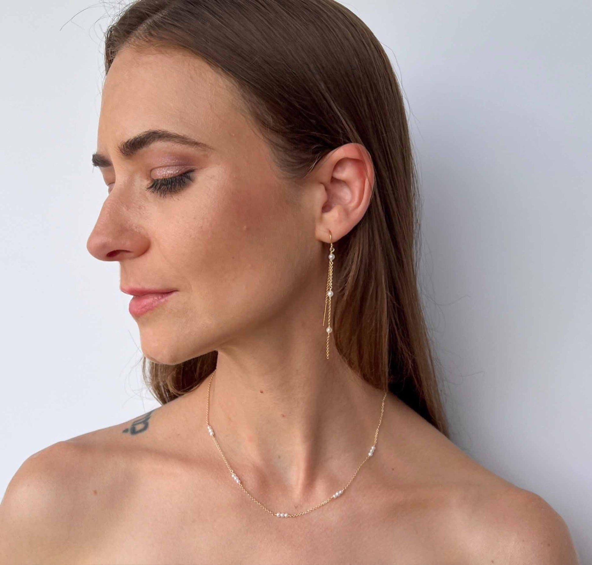 model wearing Gigi Long Pearl Earrings with matching pearl station necklace