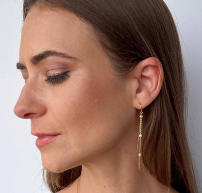 model wearing Gigi Long Pearl Earrings with matching pearl station necklace