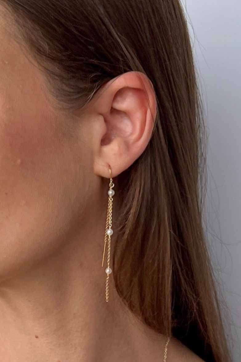 close up of model with pearl chain earrings