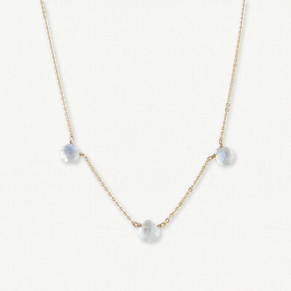 close up of triple moonstone necklace on gold chain.  3 small faceted moonstones spaced on a chain