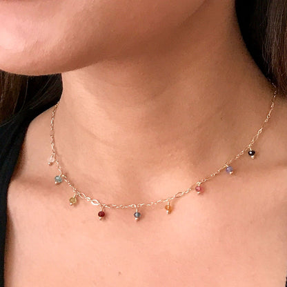 model wearing dainty gemstone necklace in gold
