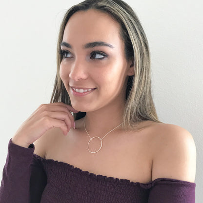 model wearing eternity or karma circle necklace in gold