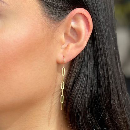 model wearing gold chain dangle earrings