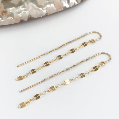 close up of gold lace pattern threader earrings