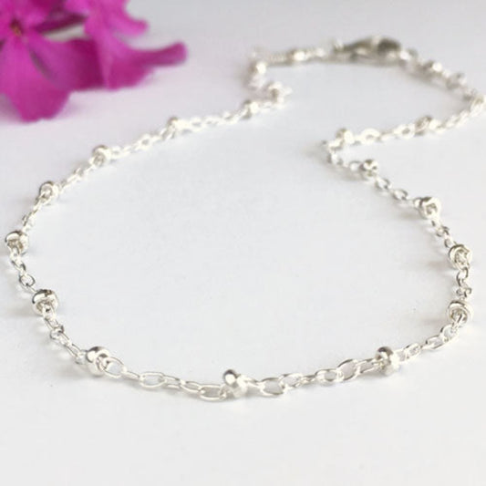 close up of sterling silver bead chain anklet