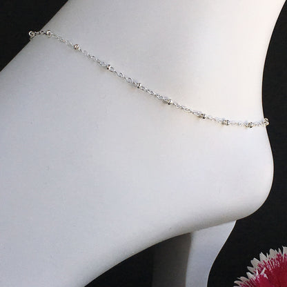 close up of sterling silver satellite chain anklet