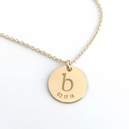 close up of .5 inch gold disc with engraved initial and date.  available in 14k gold filled or sterling silver