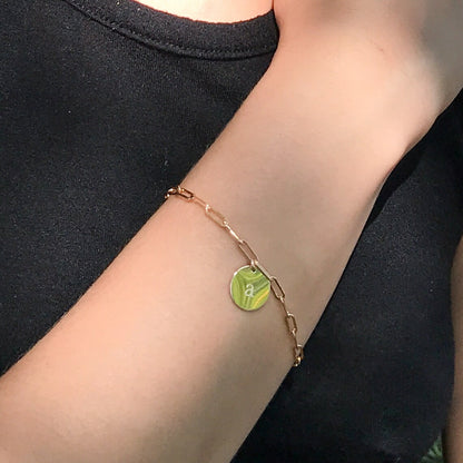close up of model wearing letter bracelet on paperclip chain